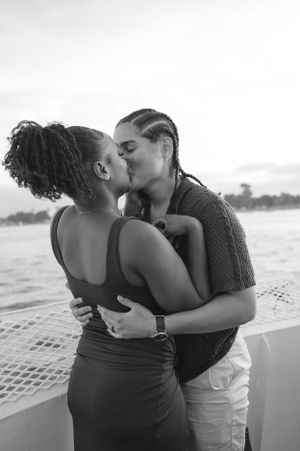 A romantic couple sharing a tender moment on a boat during sunset.
