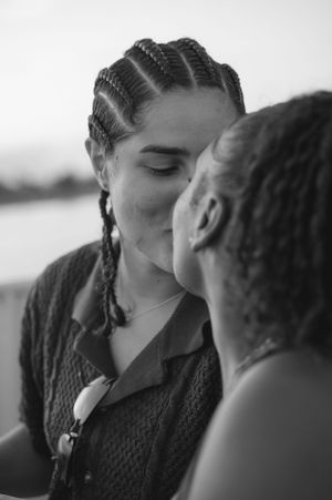 An intimate close-up shot of a couple sharing a tender moment by the water.