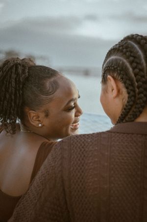 A tender moment captured between two people on a boat with water in the background.