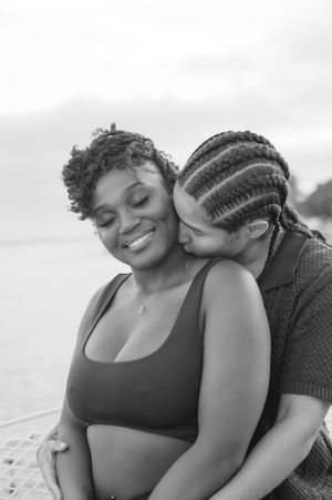 A loving couple shares an intimate moment on a boat deck during a photo session.