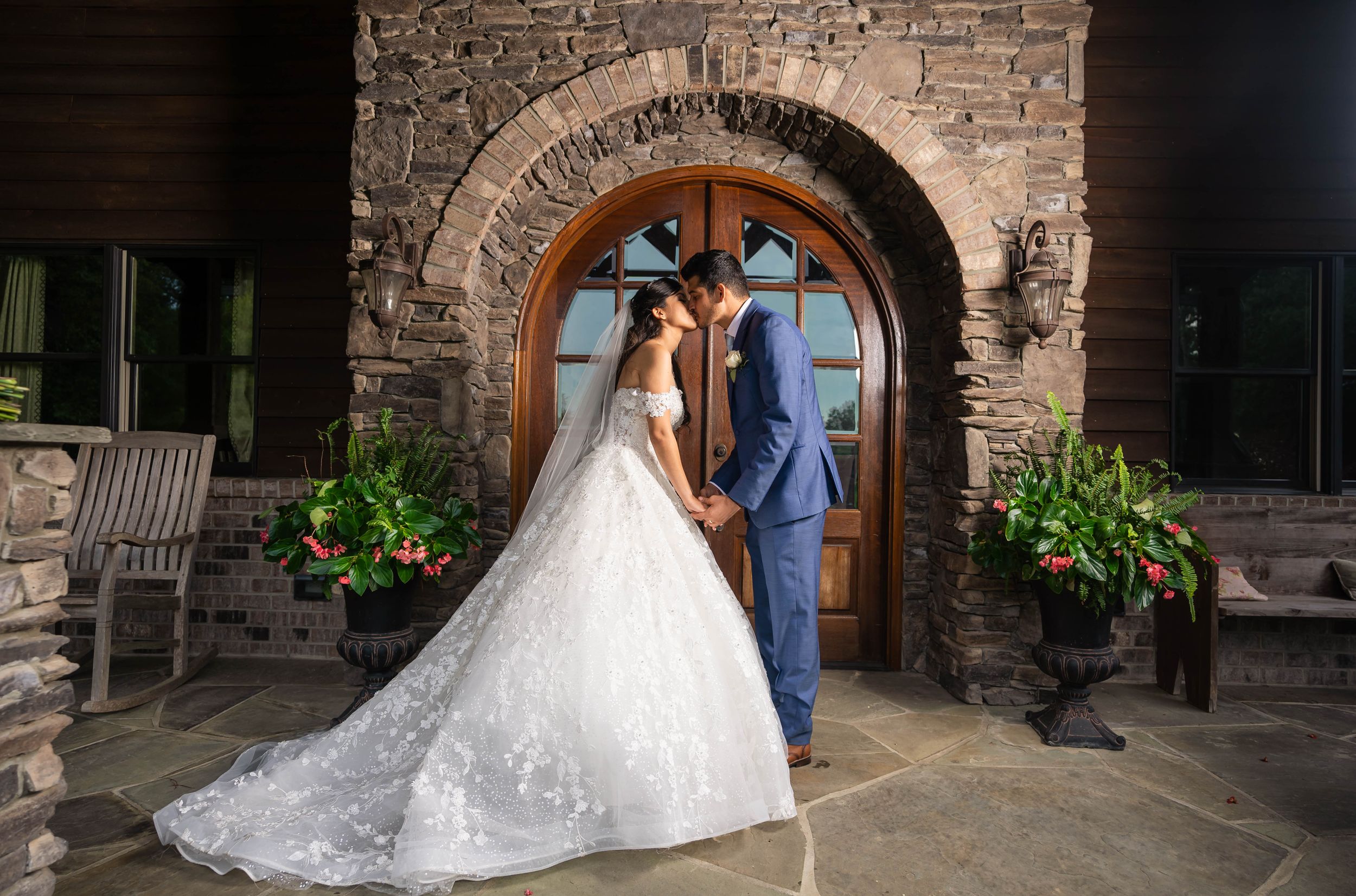 Elegant wedding portrait framed by stone archway and decorative planters.