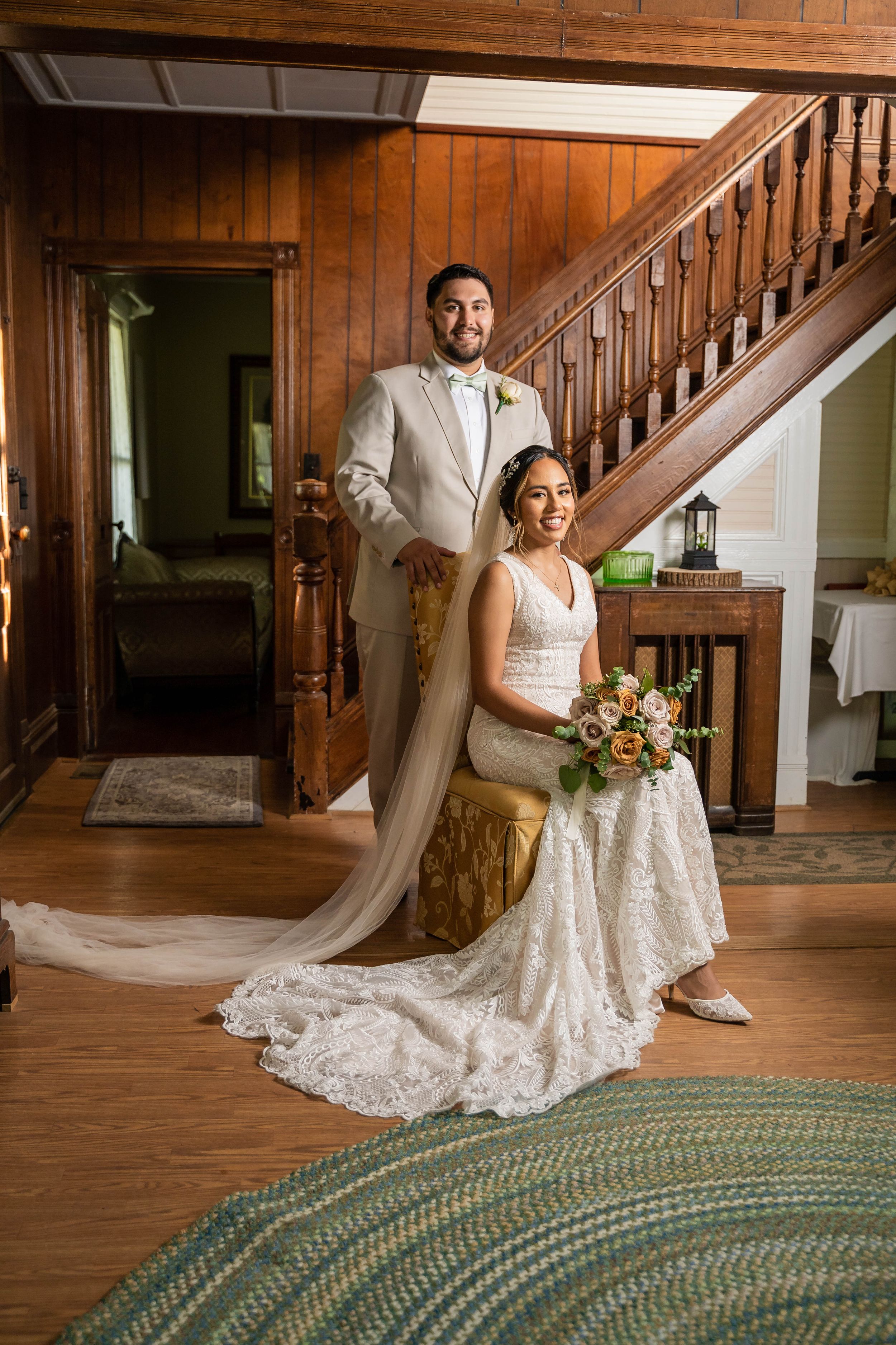Wedding portrait showcasing formal attire against beautiful wooden staircase and interior details.