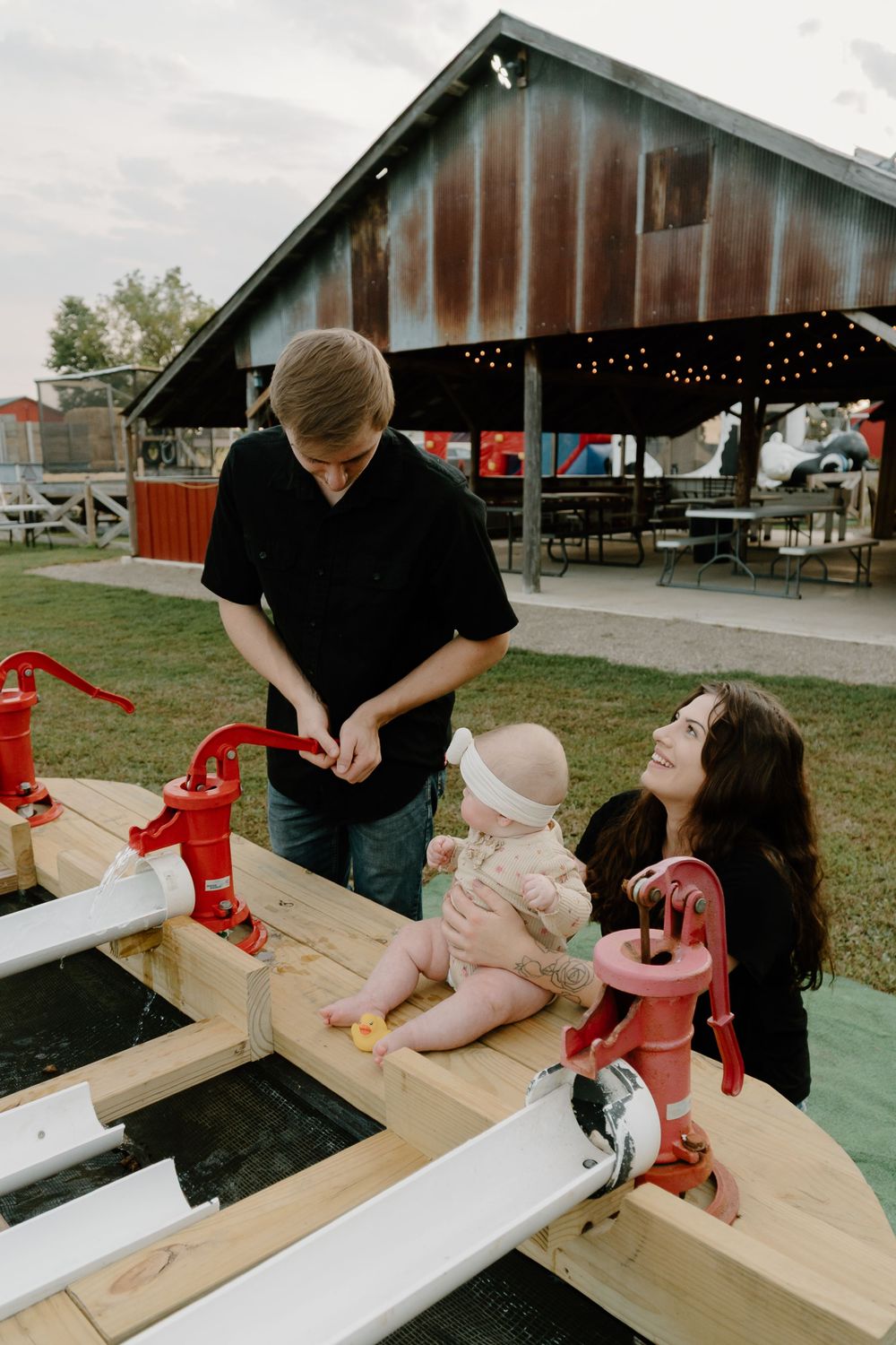 People working together to build and paint wooden structures at an outdoor workshop area.
