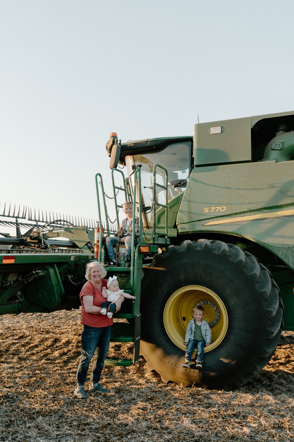 Modern combine harvester with its impressive large wheel in a harvested field.