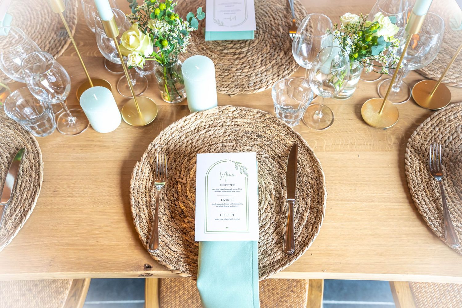 Rustic table setting featuring woven placemats, teal napkins, and small flower arrangements.