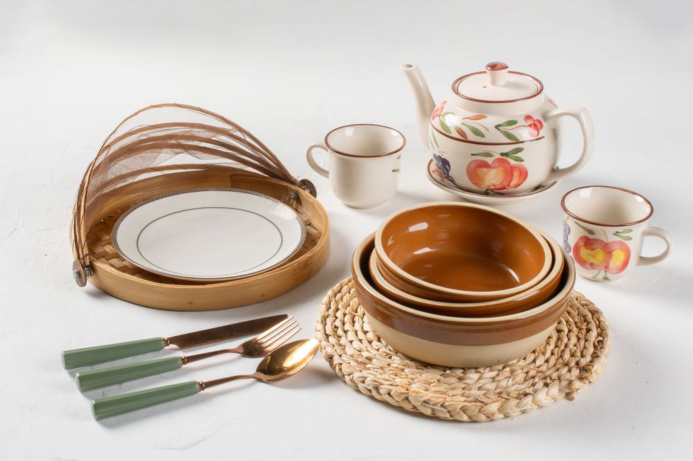 Vintage ceramic dinnerware set with brown and cream tones arranged on light background.