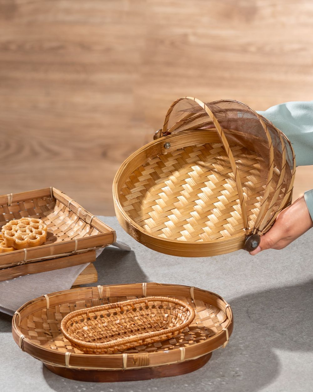 Step-by-step arrangement of natural woven bamboo baskets and trays in warm golden tones.