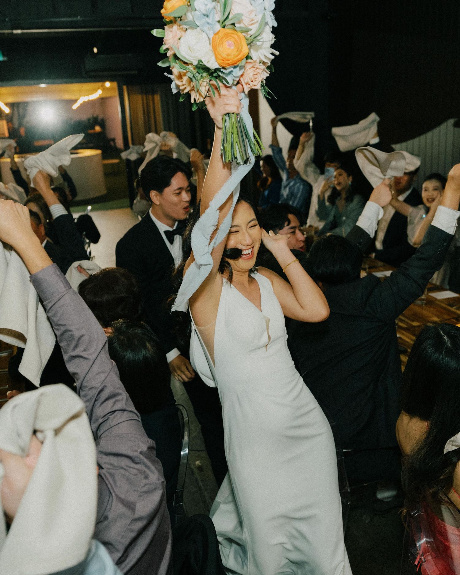 Vibrant wedding reception at The Refinery, filled with laughter and celebration, captured in a candid style