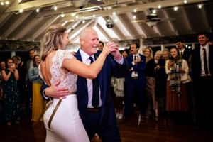 Bride shares a tender father-daughter dance at elegant wedding reception venue.