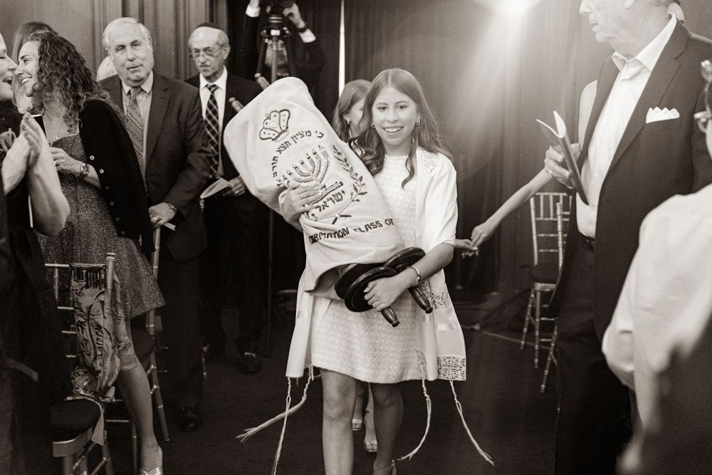 Black and white photo of celebration with guests holding decorative signs.