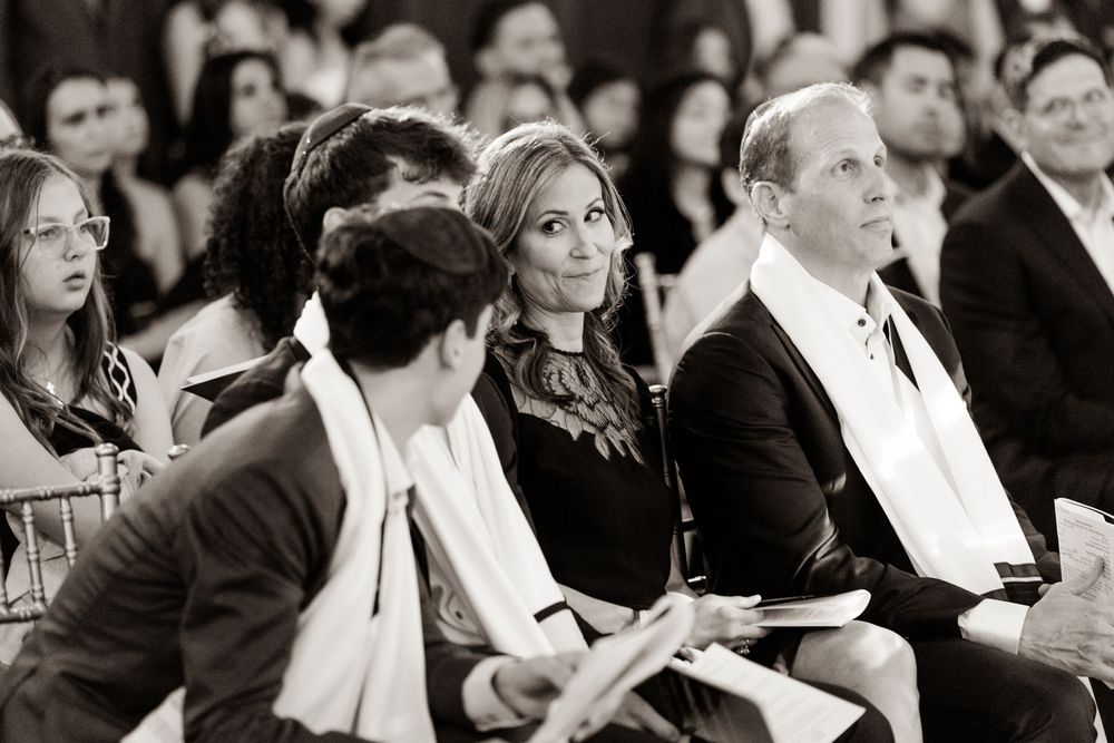 Black and white photograph of formal event attendees seated in rows during a presentation.