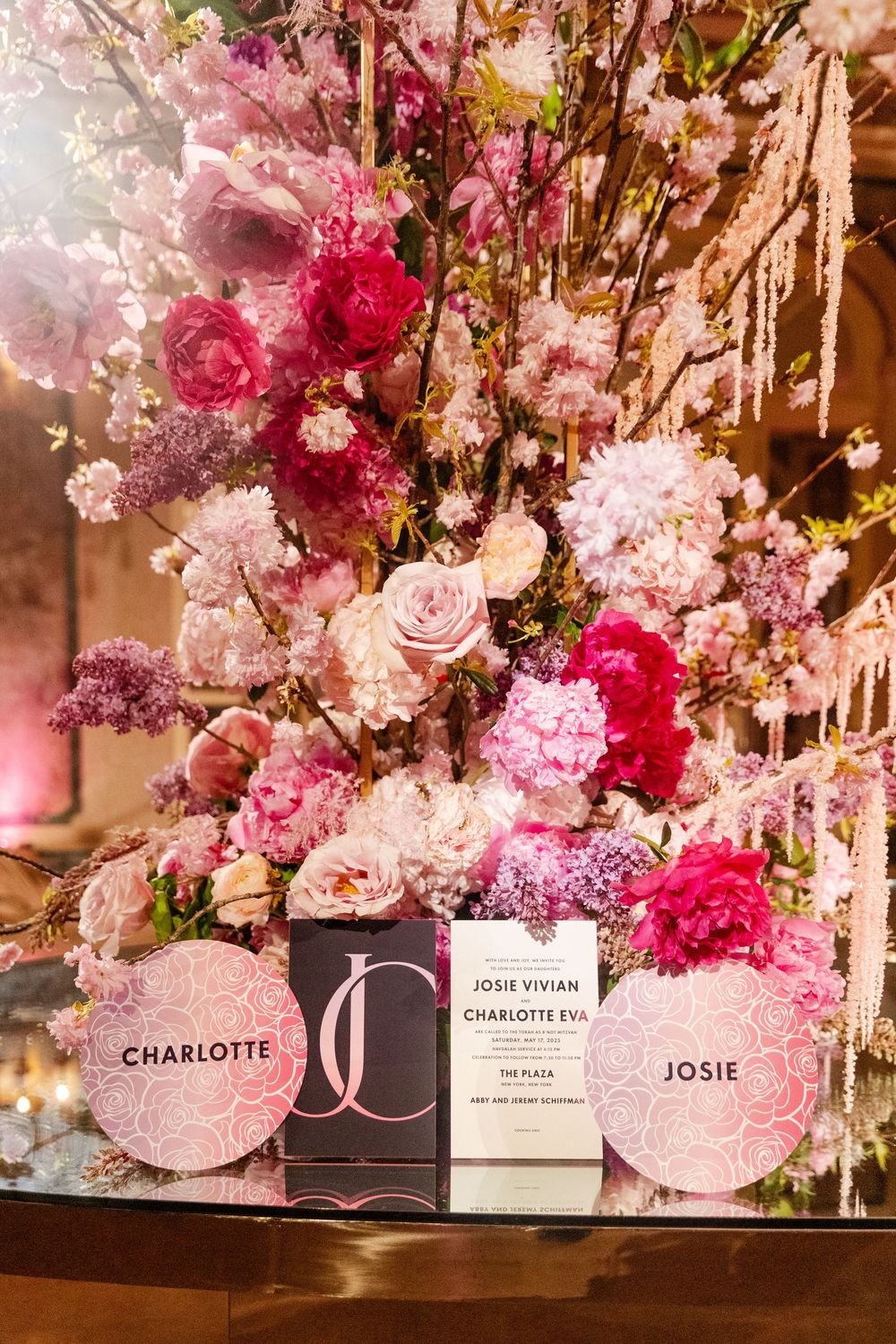 Elegant place cards and floral centerpieces in pink and white tones displayed on a luxurious table setting.
