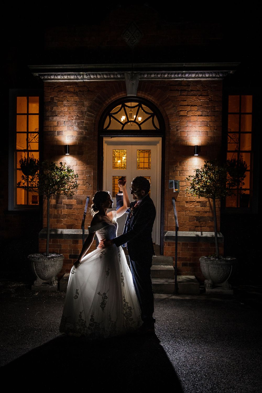 Bride and groom night portrait on the Kelham House driveway with the manor lights glowing in the background