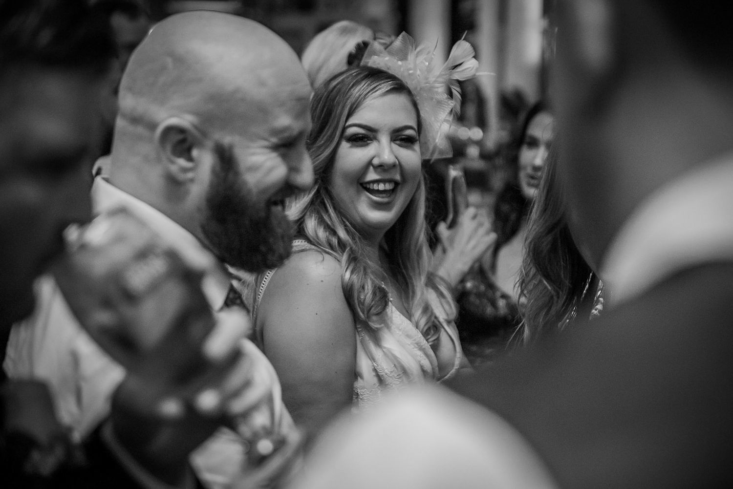 Black and white photo showing people laughing and enjoying a celebration at a social gathering.