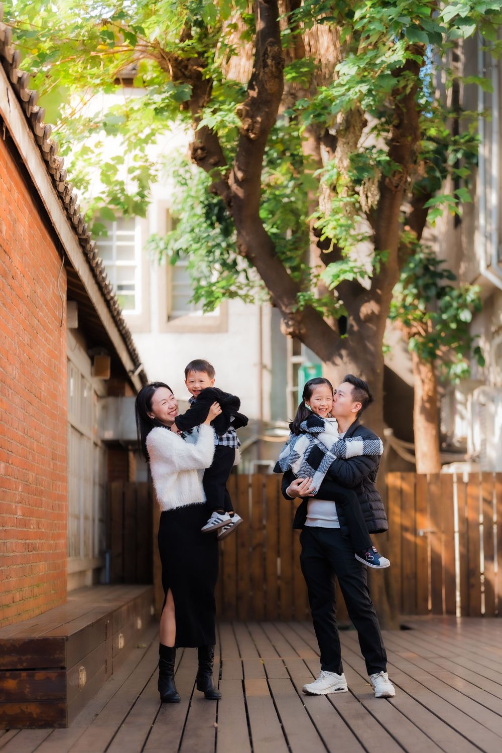 Two parents hold their son and daughter at an industrial repurposed outdoor venue in Taipei, Taiwan.