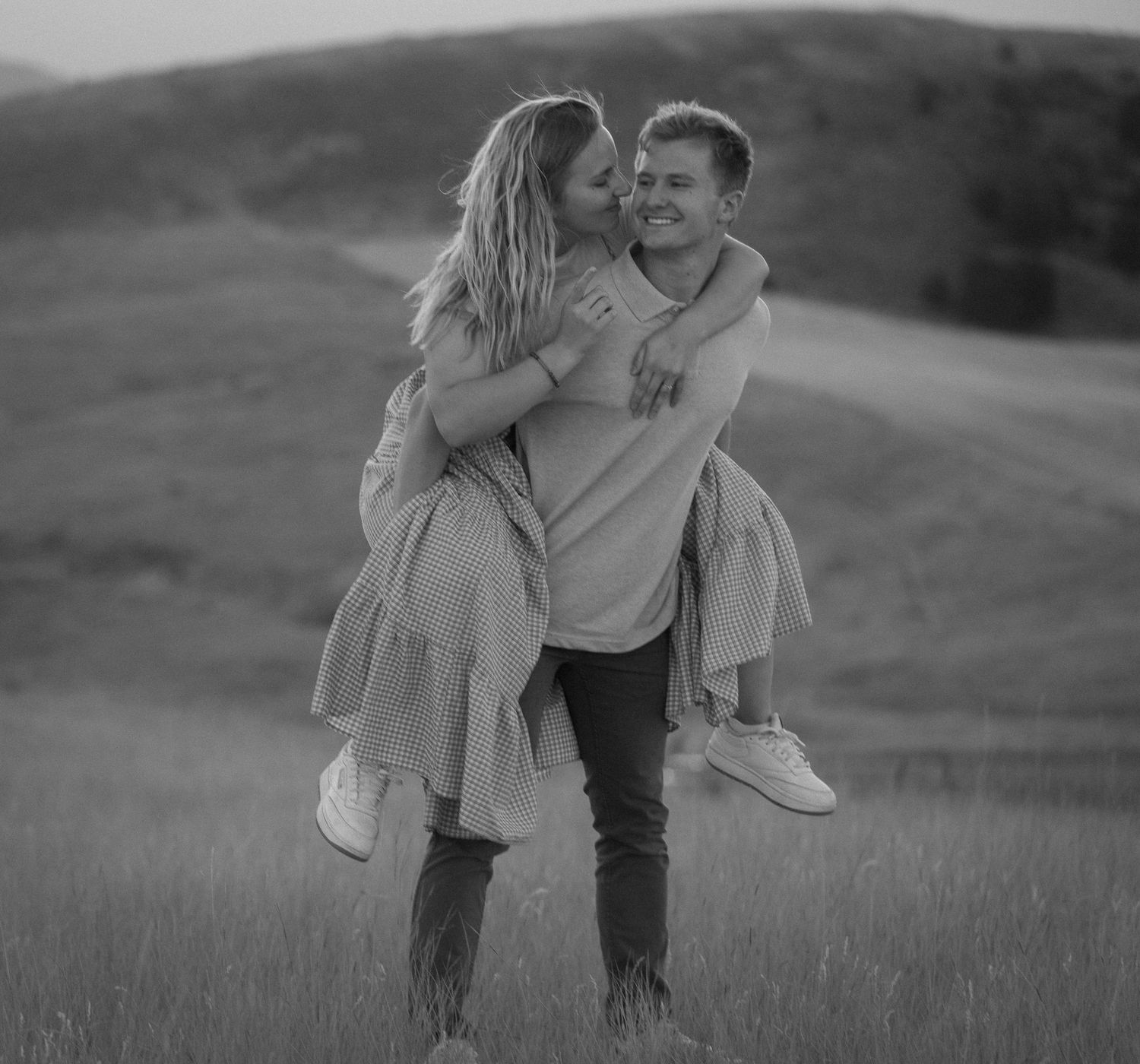 Young couple laughing and hugging in a beautiful outdoor engagement session in Logan, UT.