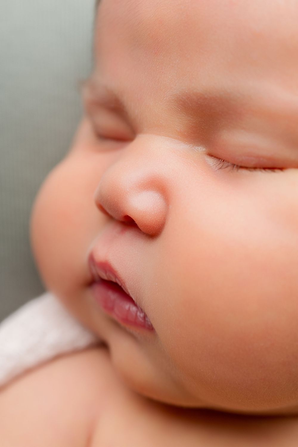 Dreamy macro shot showing delicate details of a baby's nose and lips while sleeping.