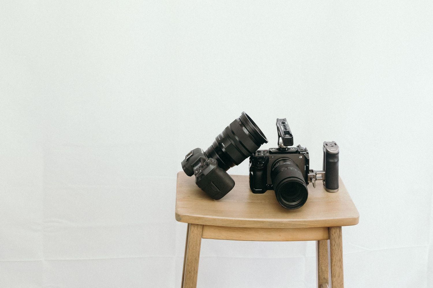 Professional camera equipment displayed on a wooden table against white background.