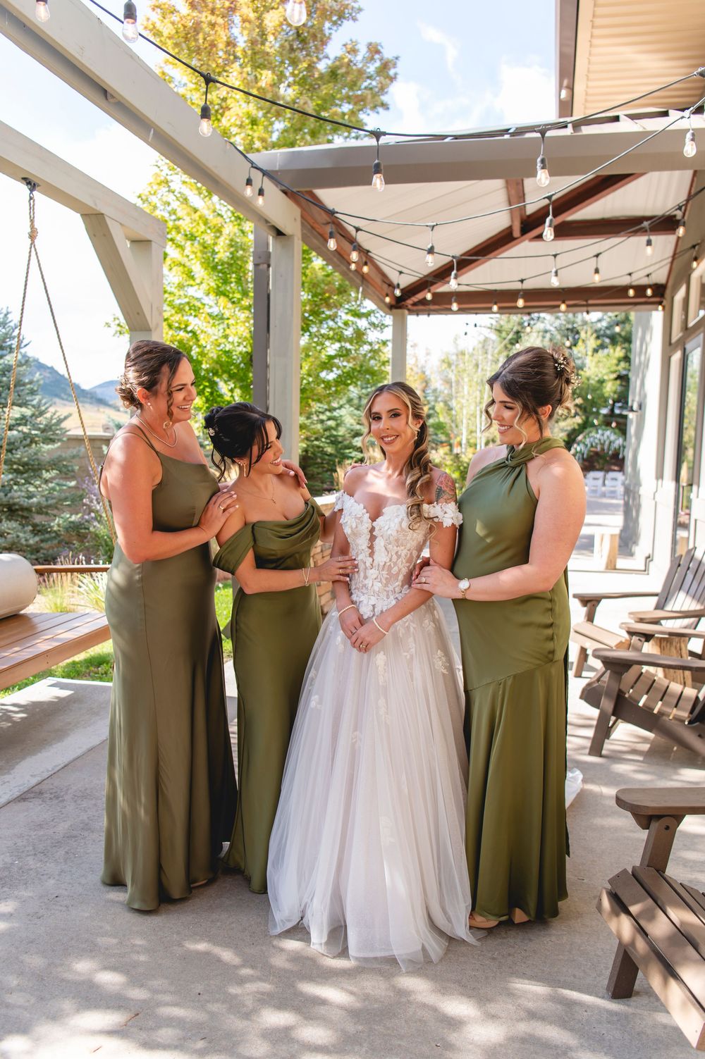 A sequence of five photos showing a bride and bridesmaids in olive green dresses sharing a drink together on a patio.