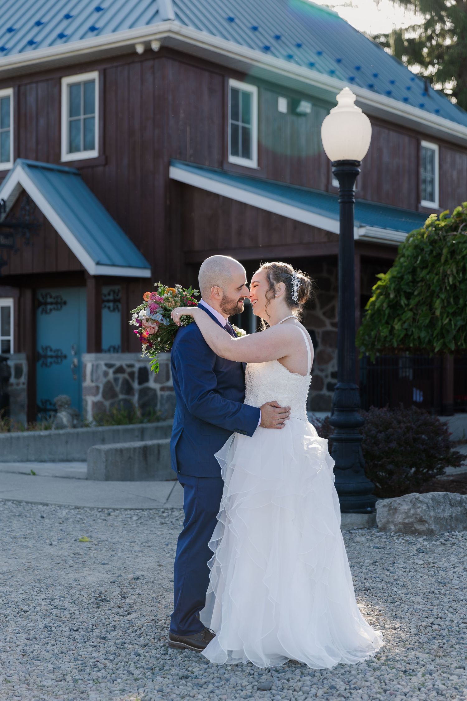 Newlyweds share a romantic kiss in front the wooden building at the back of Hauser Hall in Kitchener, Ontario.