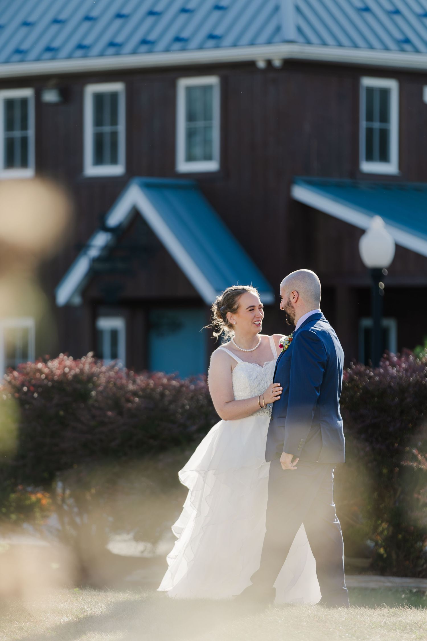 Bride and groom share a private conversation away from guests in the first beside Hauser Hall in Kitchener, Ontario.