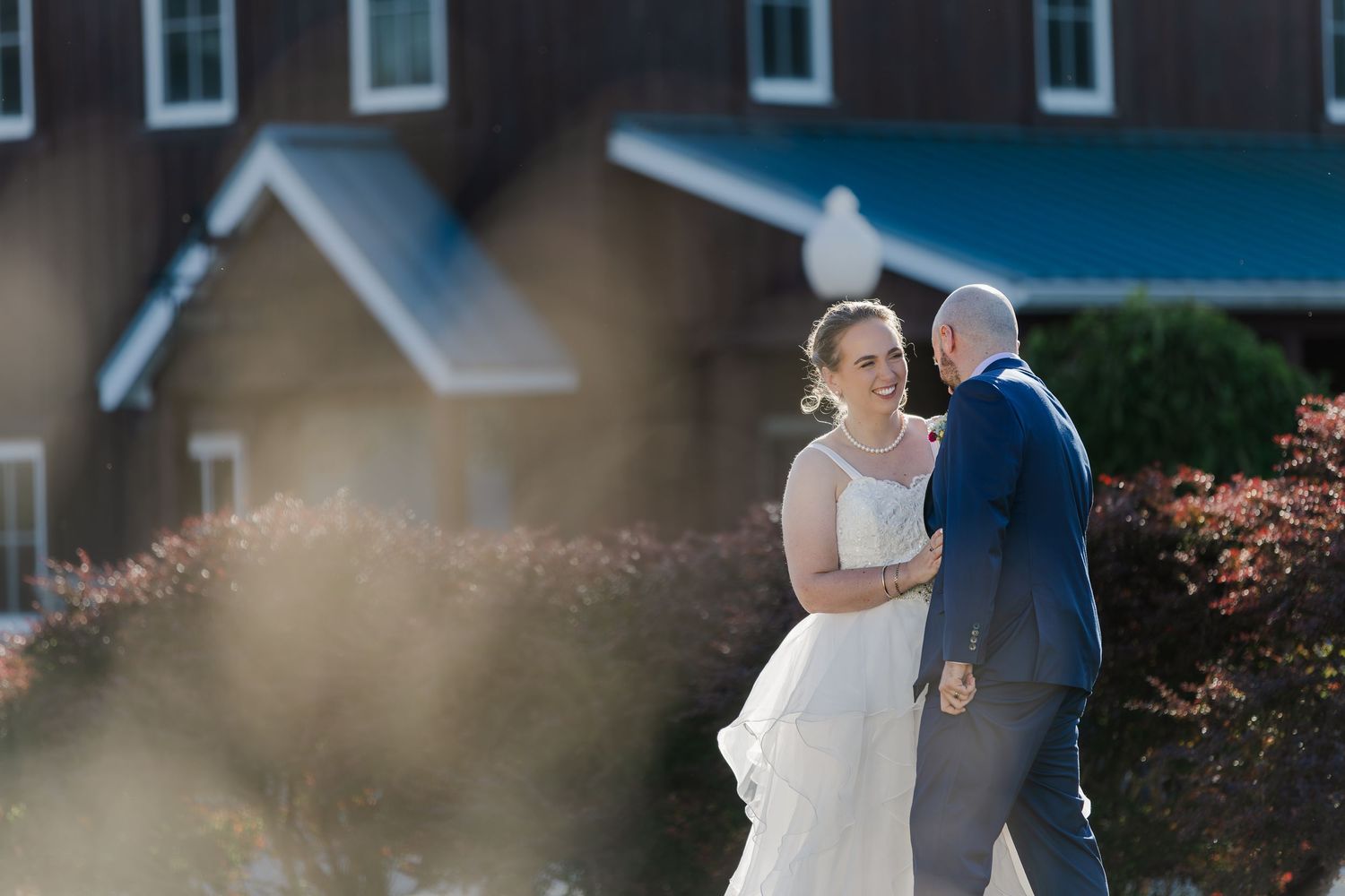 Bride and groom laughing together outside Hauser Hall in Kitchener, Ontario.