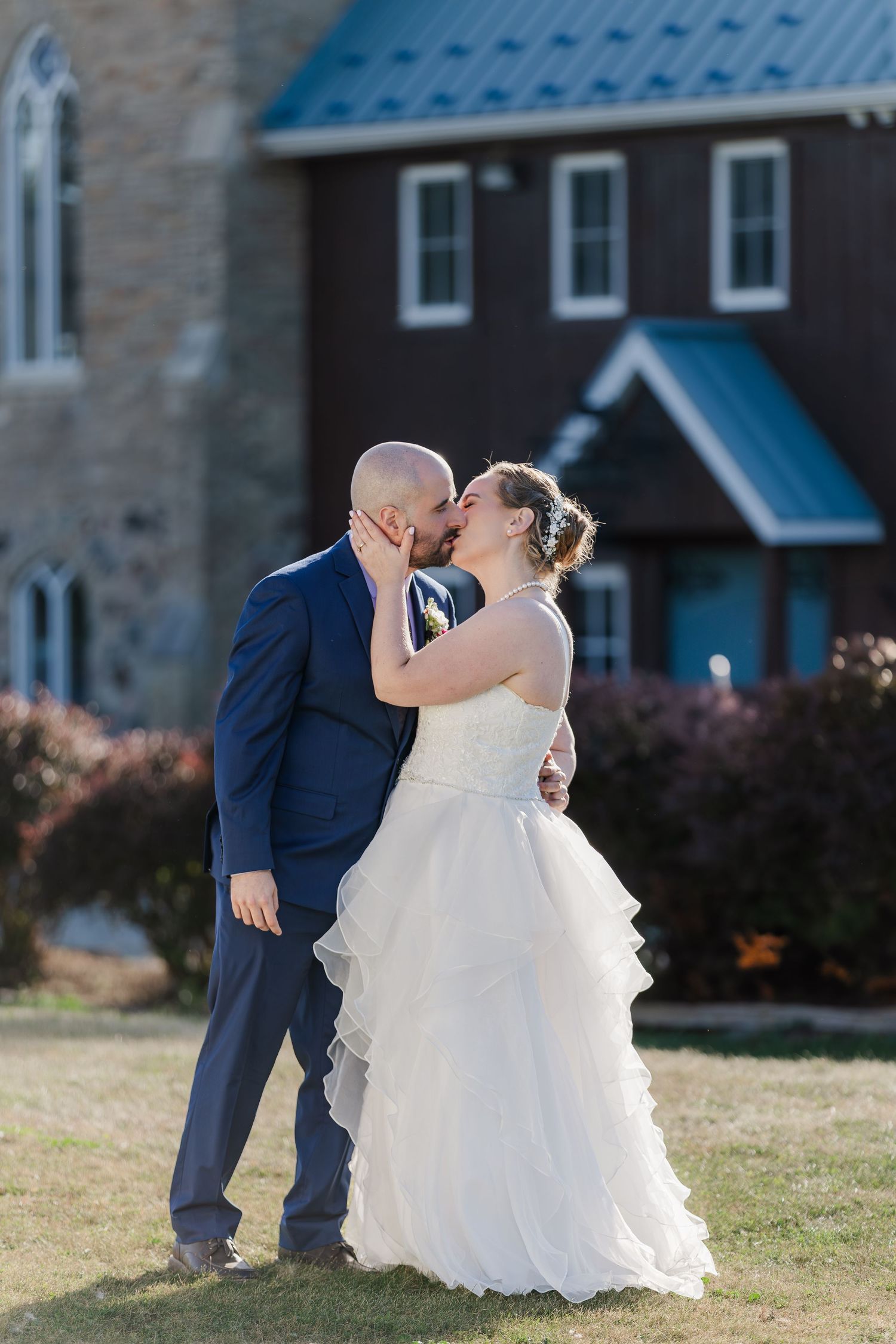 Bride and groom share a tender and romantic moment on the lawn beside Hauser Hall in Kitchener, Ontario.