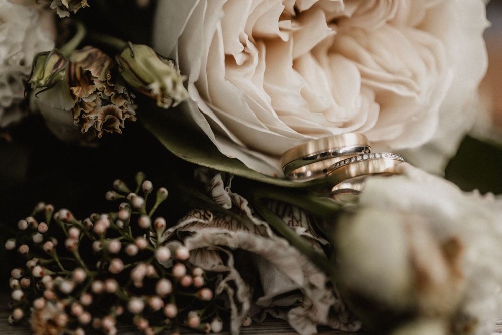 Close-up detail of an engagement ring and delicate blush pink roses with soft bokeh background effect.