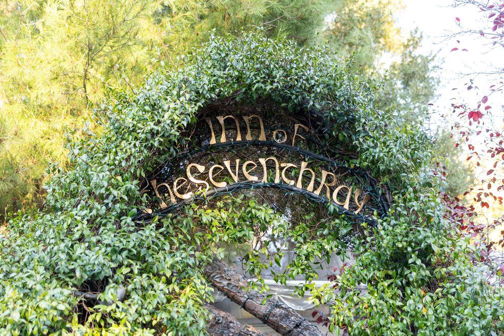 A decorative stone garden path winds through lush greenery and flowering plants in a tranquil garden setting.