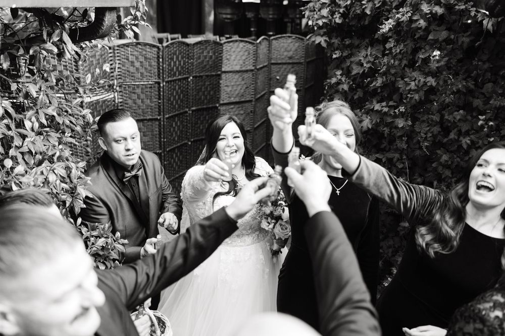 Black and white sequence showing playful moments among guests at an outdoor celebration.
