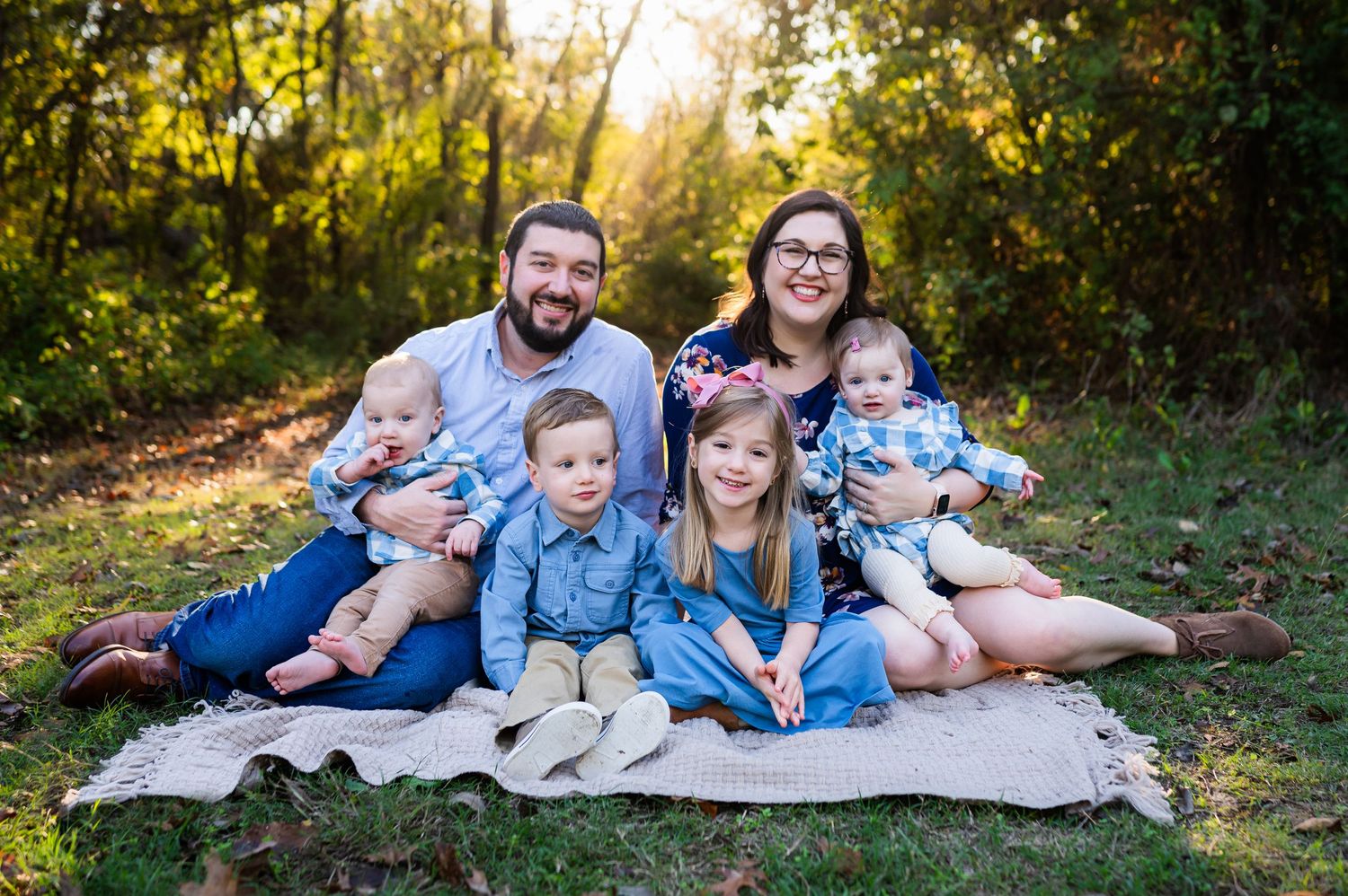 dallas outdoor fall family photos of family of six seated on blanket; infants in mom and dad's lap and preschool aged kids in front