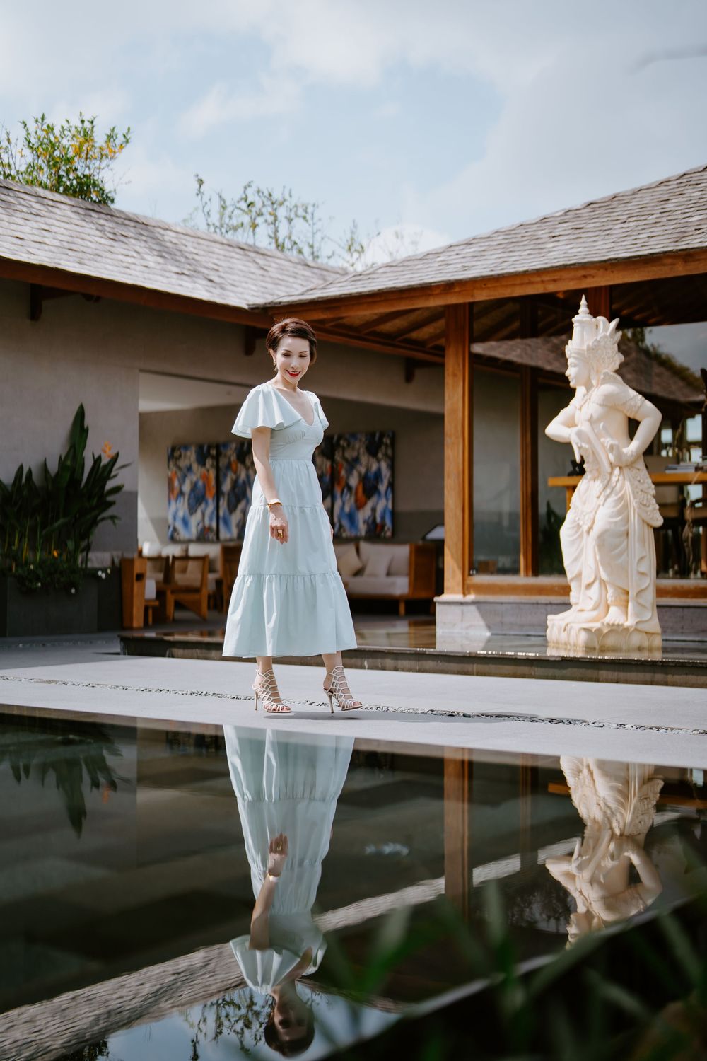 Reflective pool photoshoot at a luxury tropical resort with architectural features.