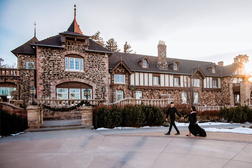 a man holding his wife's hand as he leads her across the Highlands Ranch castle grounds