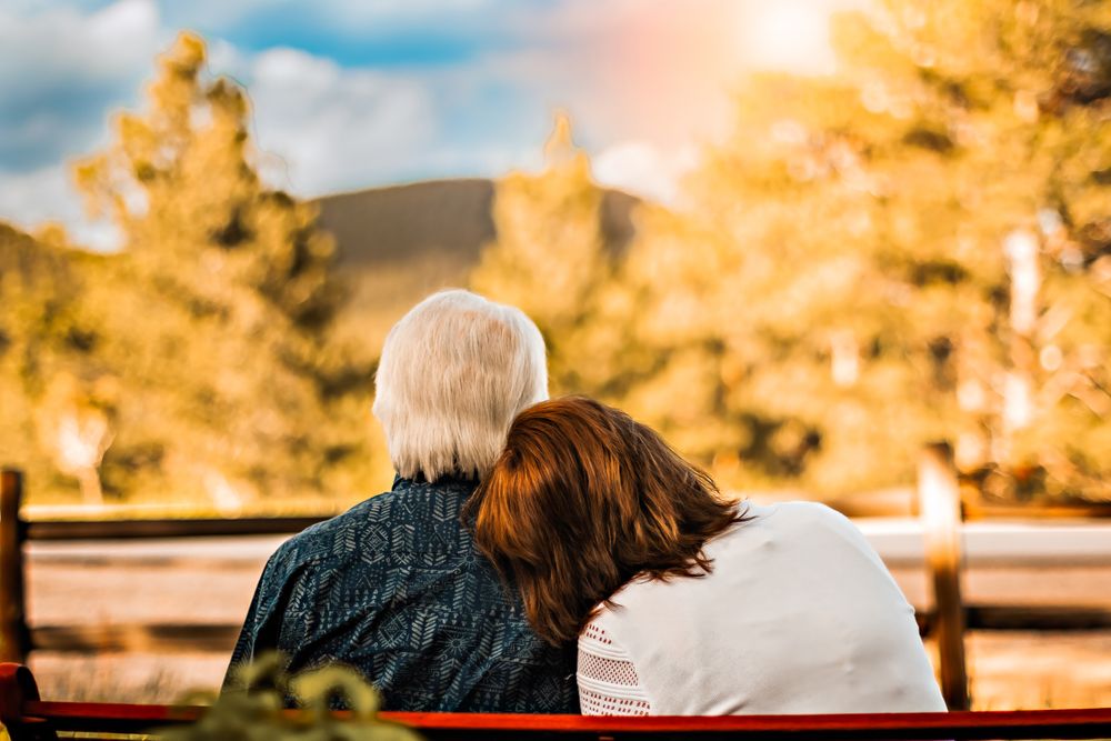 an elderly couple resting their heads against one another as they gaze into the mountain view of Lyons, CO