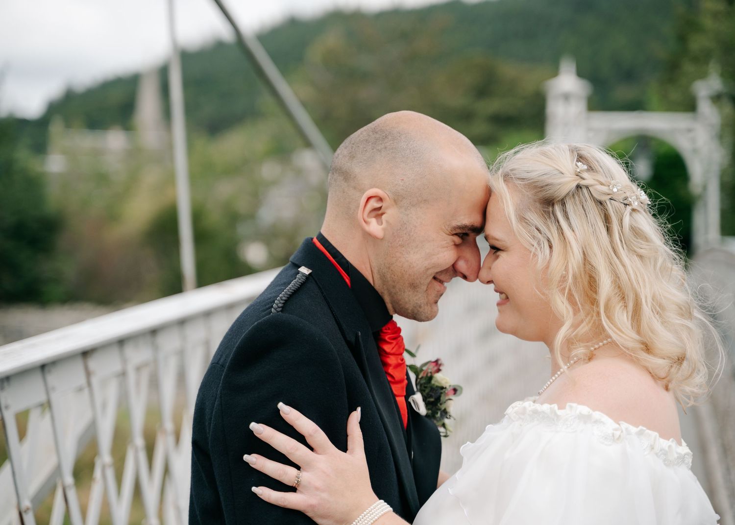 Romantic couple sharing intimate moment on bridge during wedding photoshoot by Scottish wedding photographer.