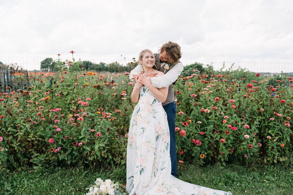 landscape bride & groom portrait in front of zinnia wildflowers at lowe park marion iowa taken by midwest cedar rapids wedding photographer