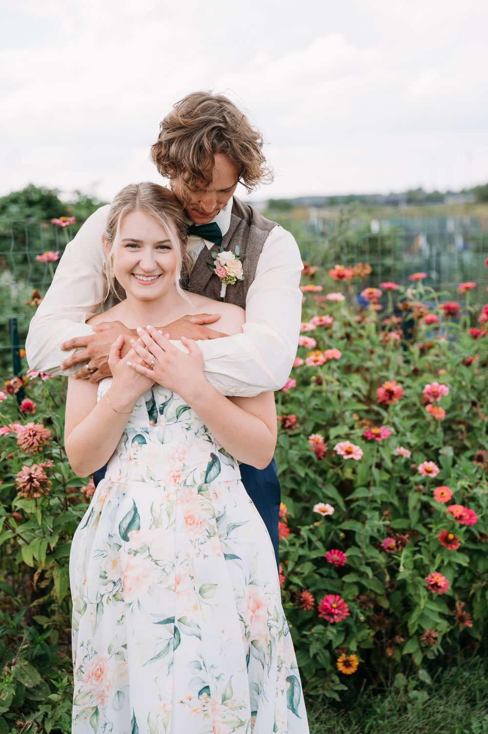 bride & groom portrait in a field full of zinnia wildflowers at lowe park marion iowa taken by midwest cedar rapids wedding photographer