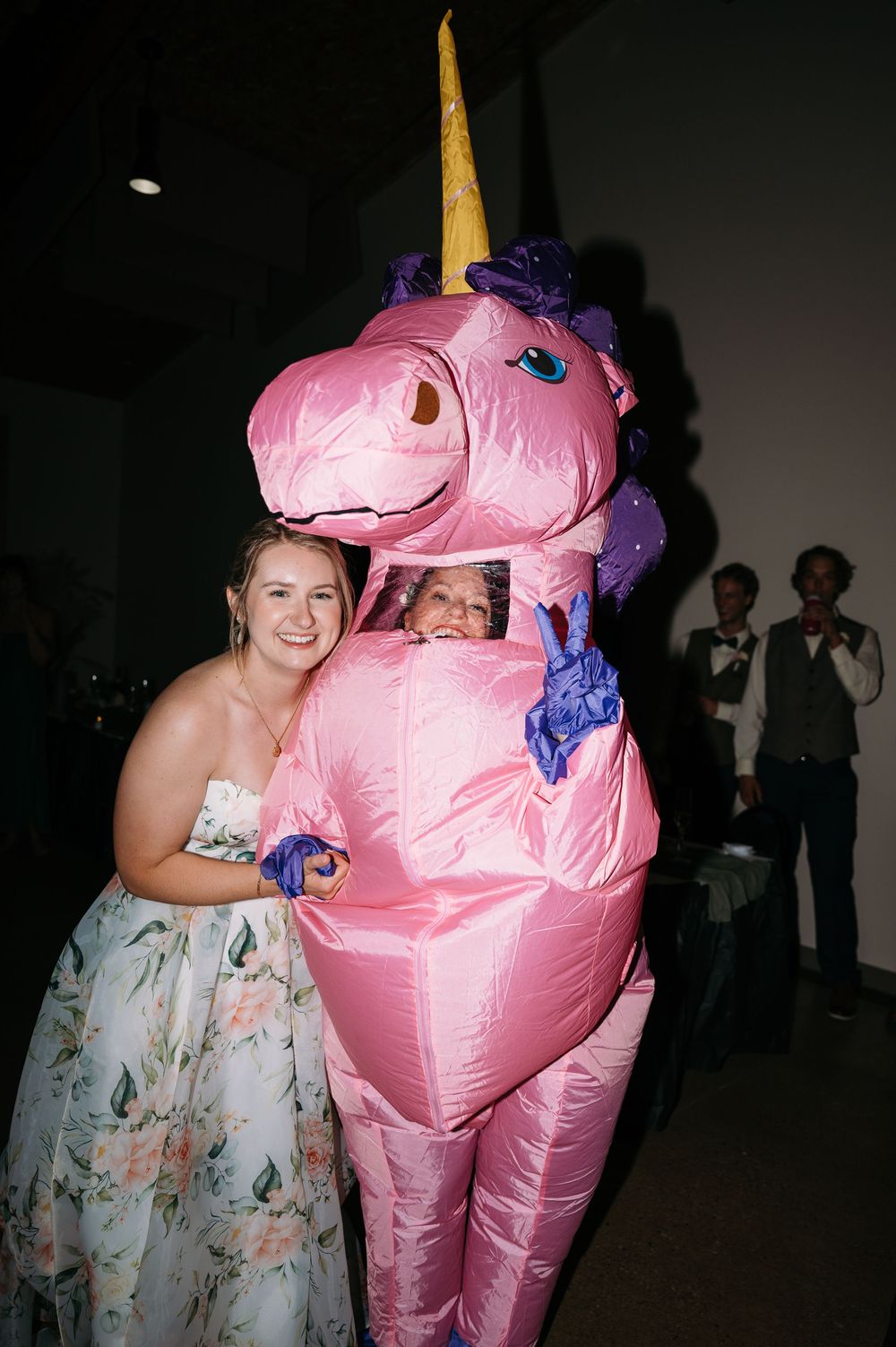 photo of bride during reception with friend dressed in blow up pink pony costume at lowe park in marion iowa by midwest wedding photographer