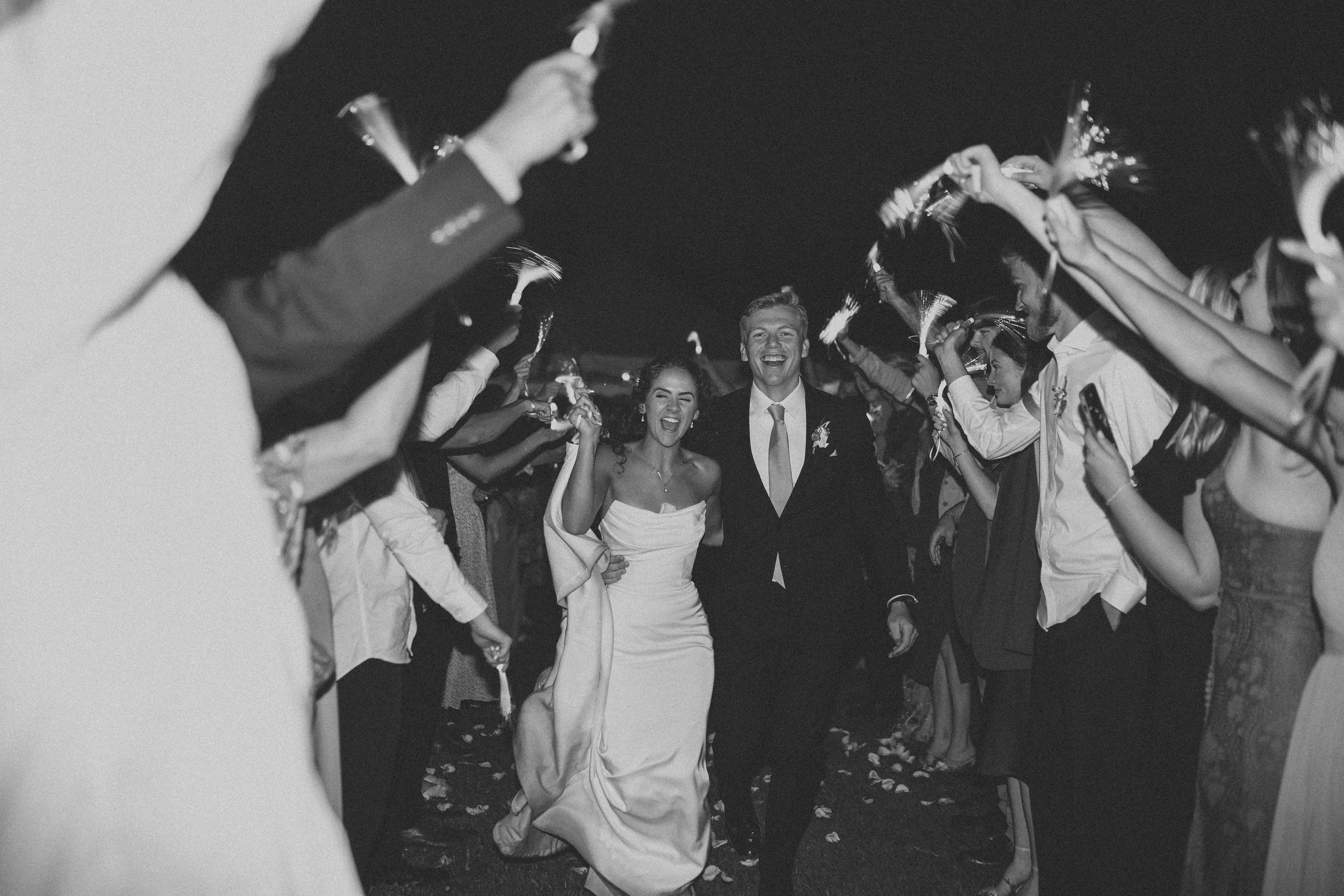 Bride and groom making their wedding exit with guests cheering at a North Idaho celebration