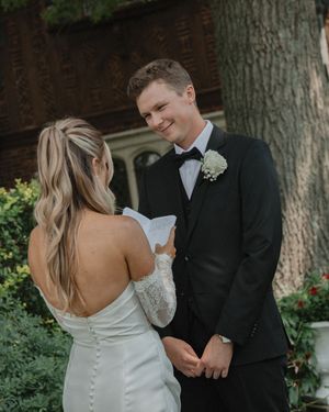 A romantic wedding couple shares intimate moments in a garden setting with trees and greenery in the background.