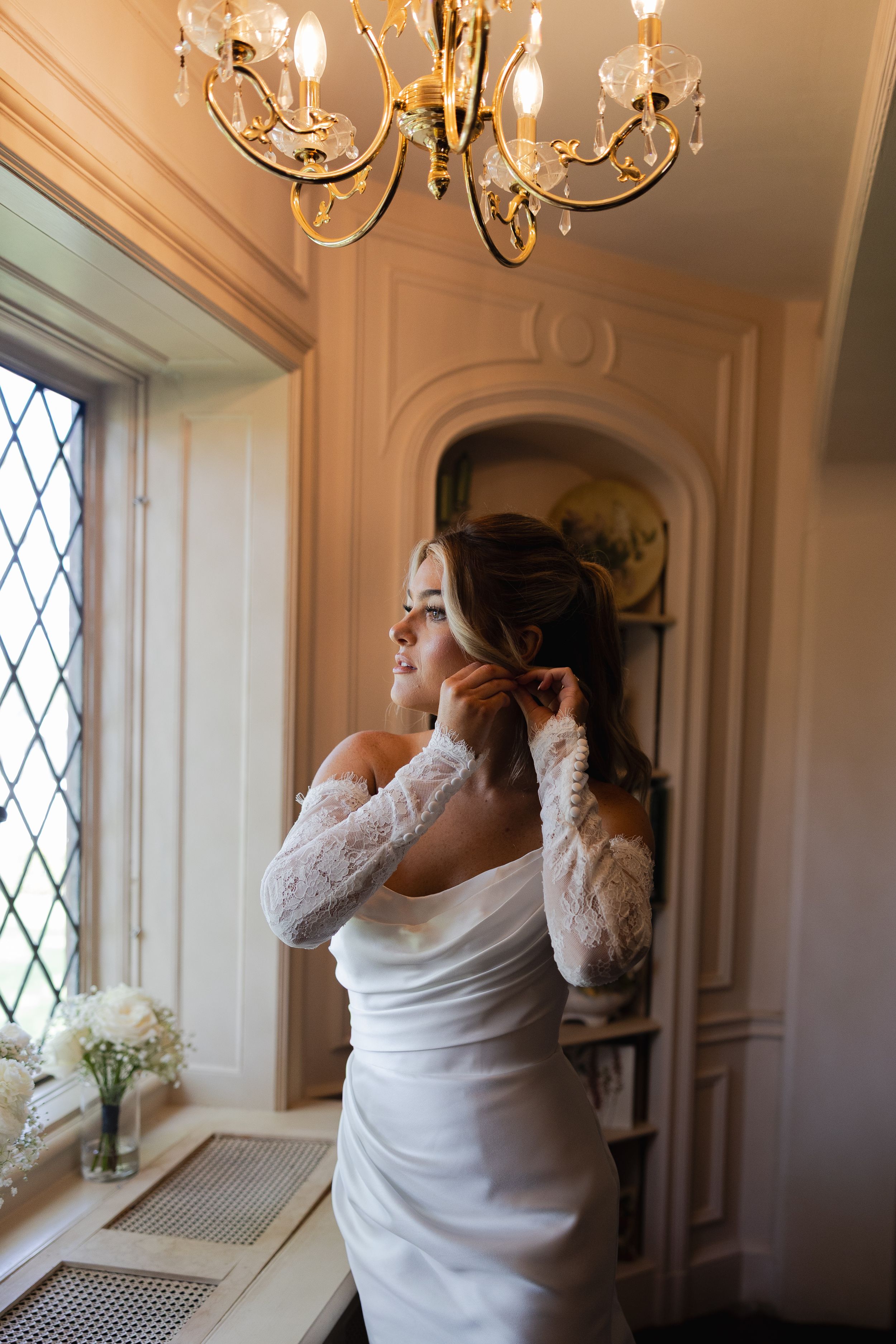 A sequence of photos shows someone in white getting ready by a window with elegant chandeliers in an ornate room.