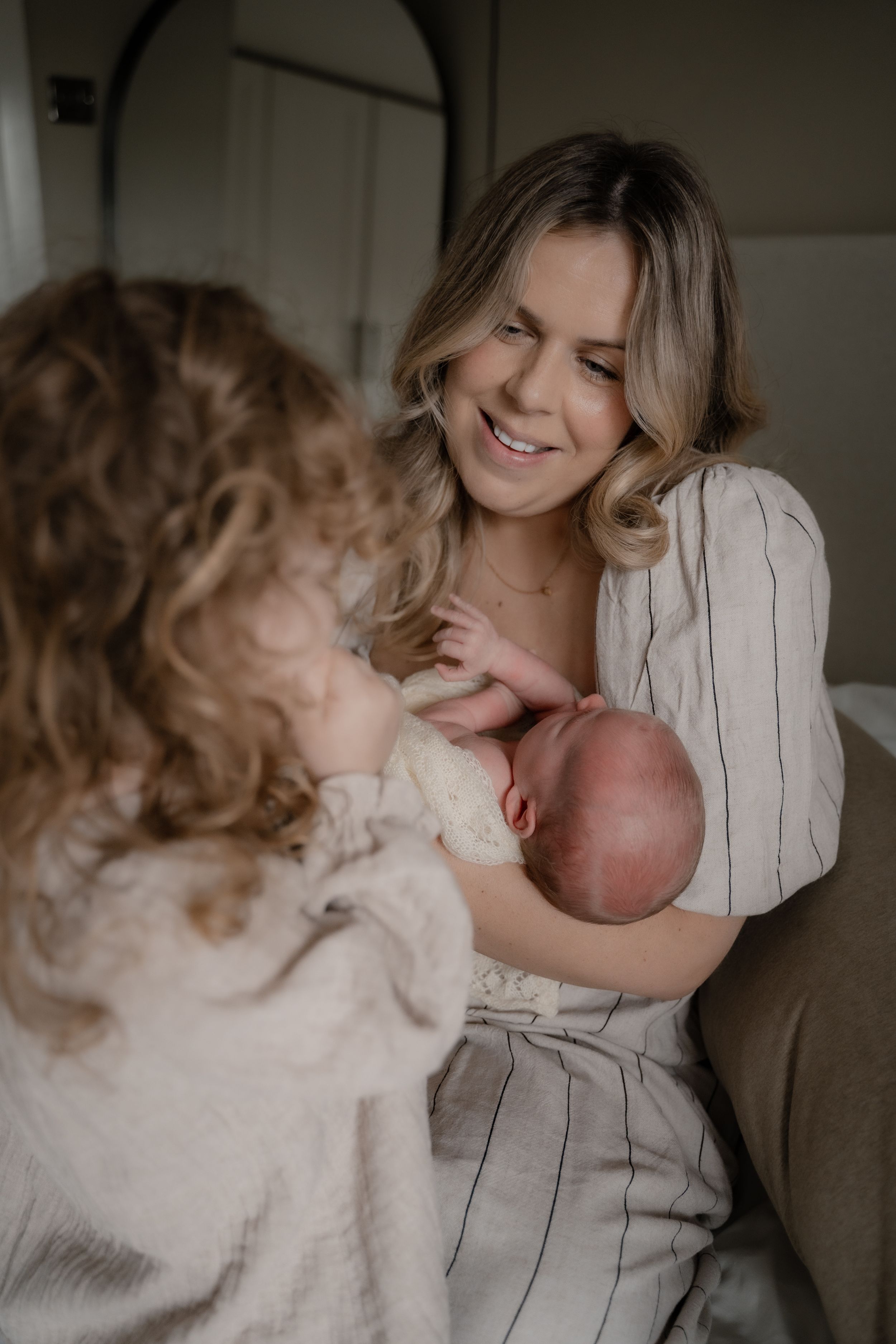 A tender family moment captured in warm indoor lighting as a parent and child share loving embraces and laughter.