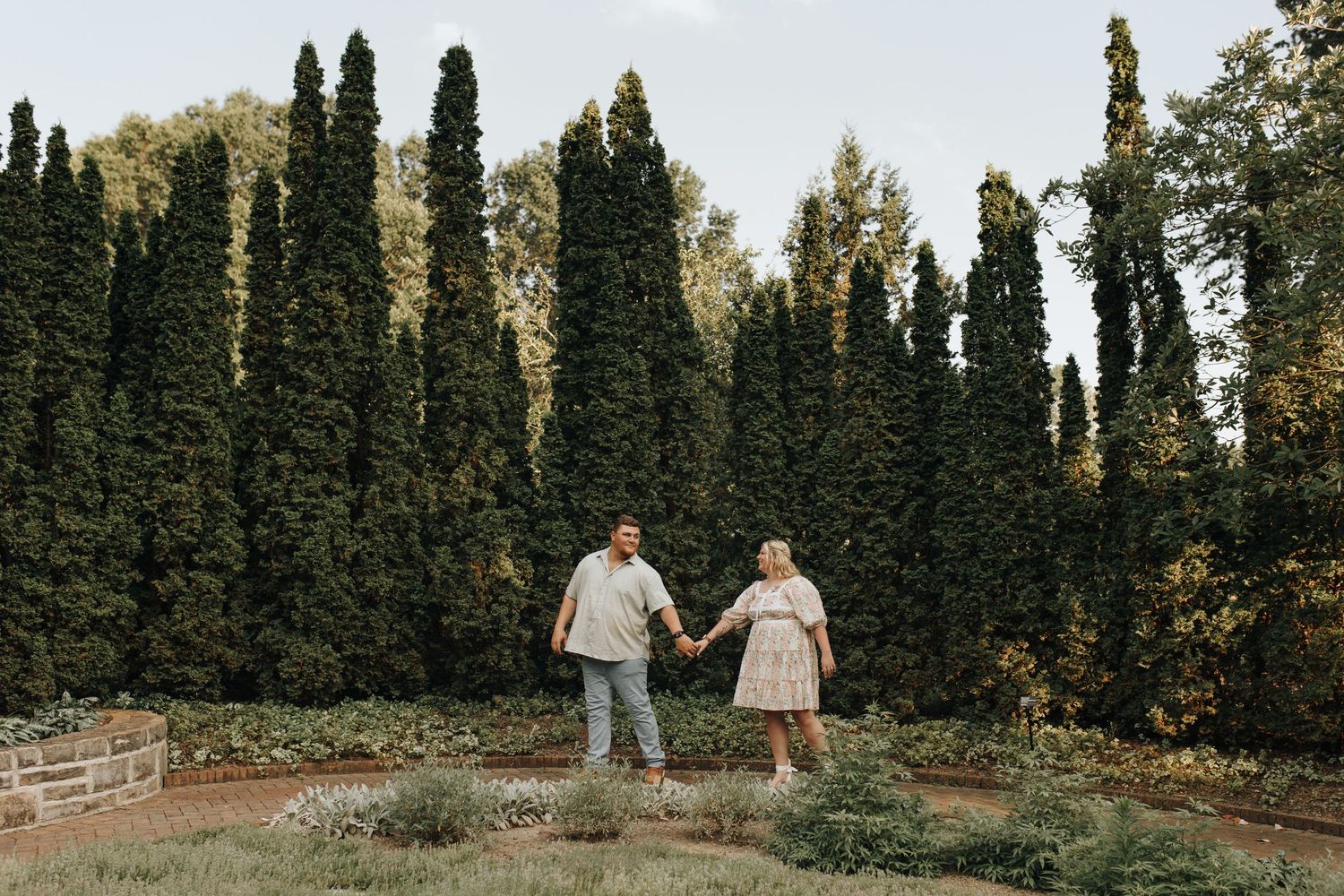 Couple walking through metro gardens on a warm, golden summer evening.