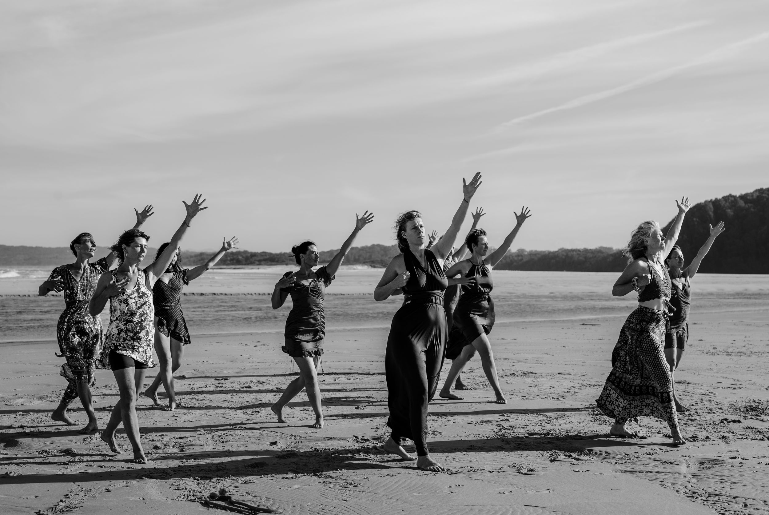 Black and white photo of women dancing Bolero on a beach.