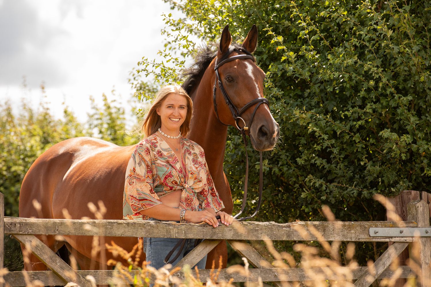 A beautiful black and white paint horse stands with a person on a sunny autumn day outdoors.