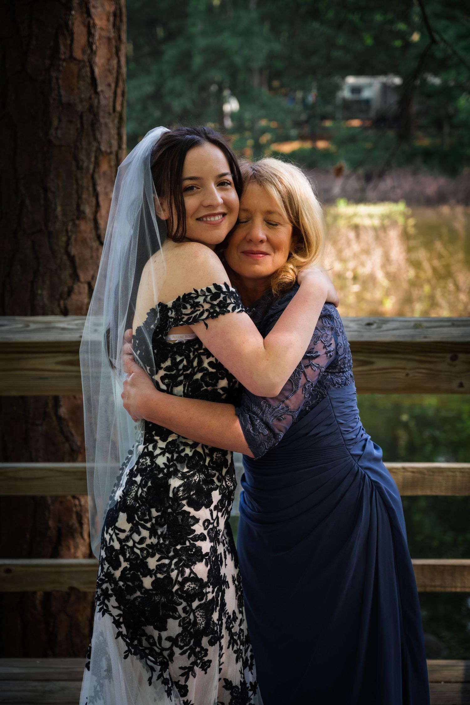 Emotional moment captured between Mother of bride and  bridal party on wooden deck.