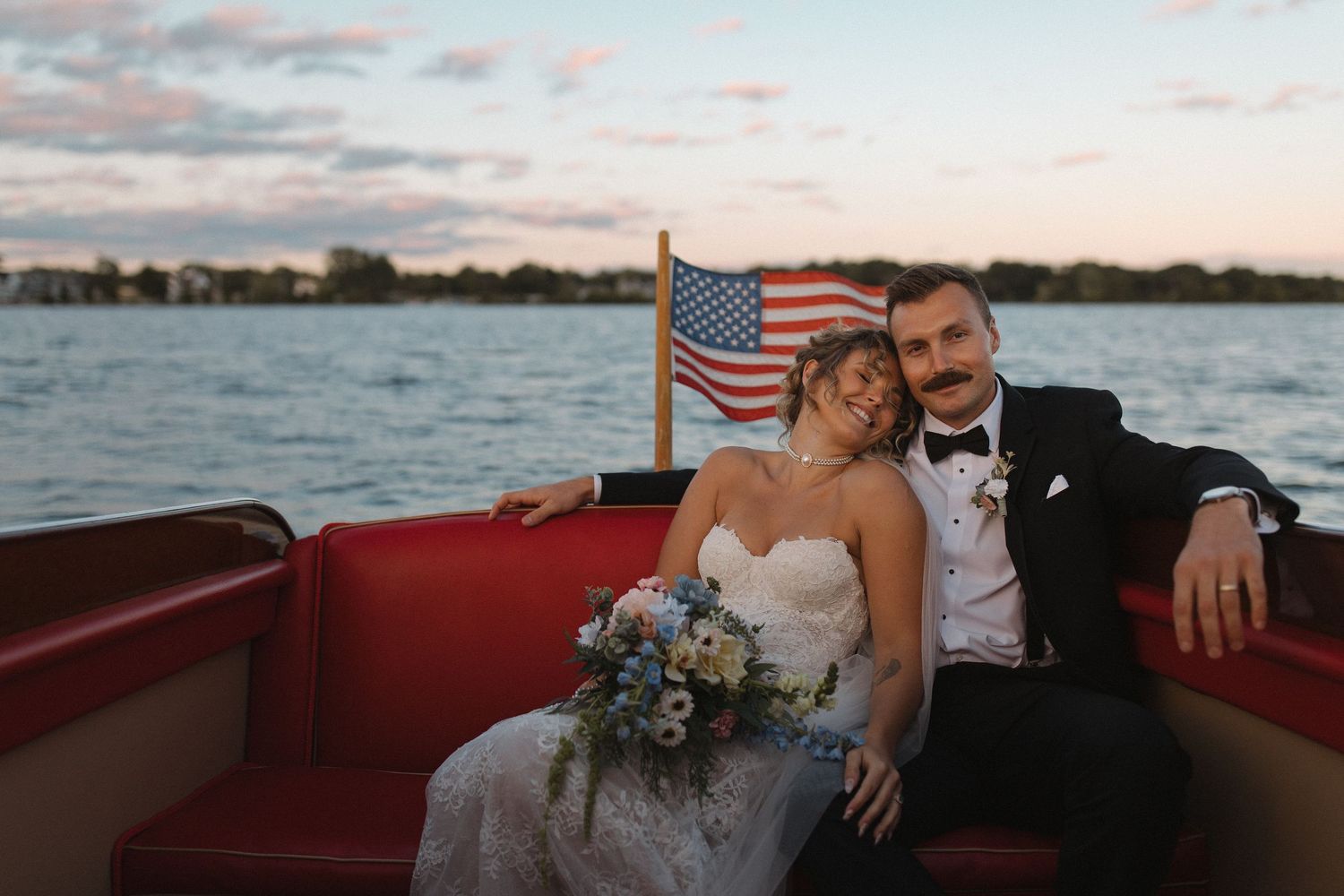 A romantic boat ride at sunset with a couple in formal attire celebrating their wedding day.