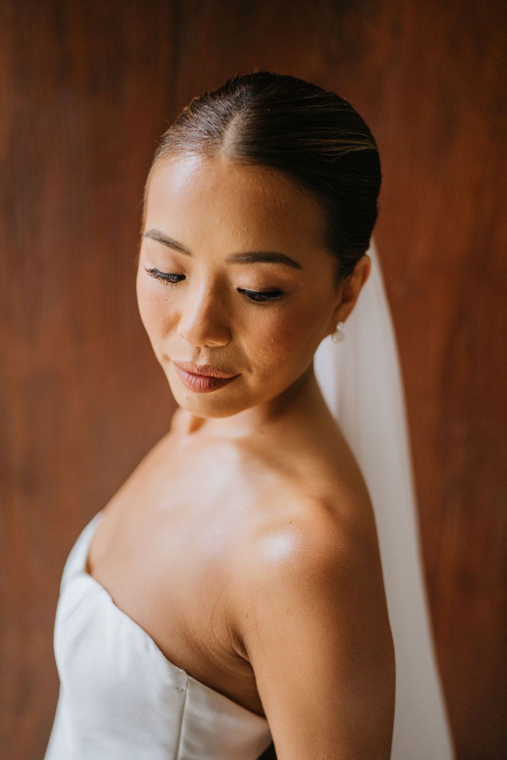Close-up portrait showing elegant bridal makeup and bare shoulders.