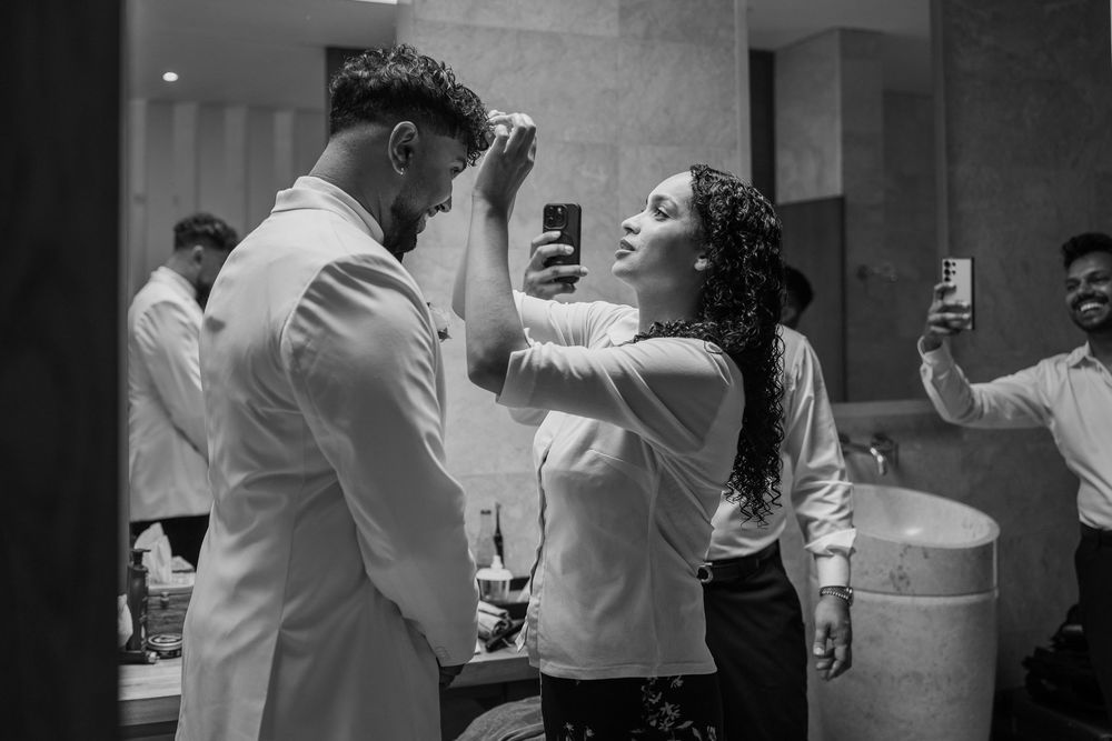 Black and white photo of wedding party getting ready in formal attire.