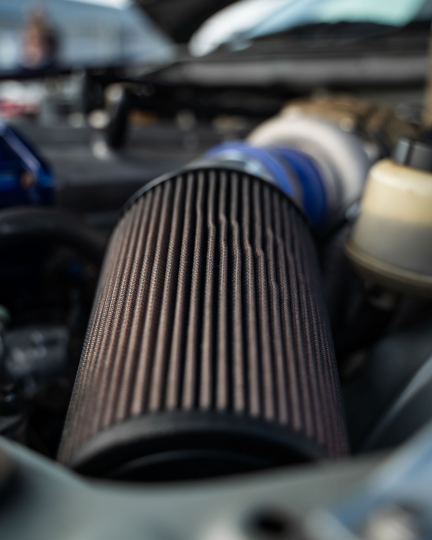 Close-up view of a performance air filter with ribbed design in engine bay.